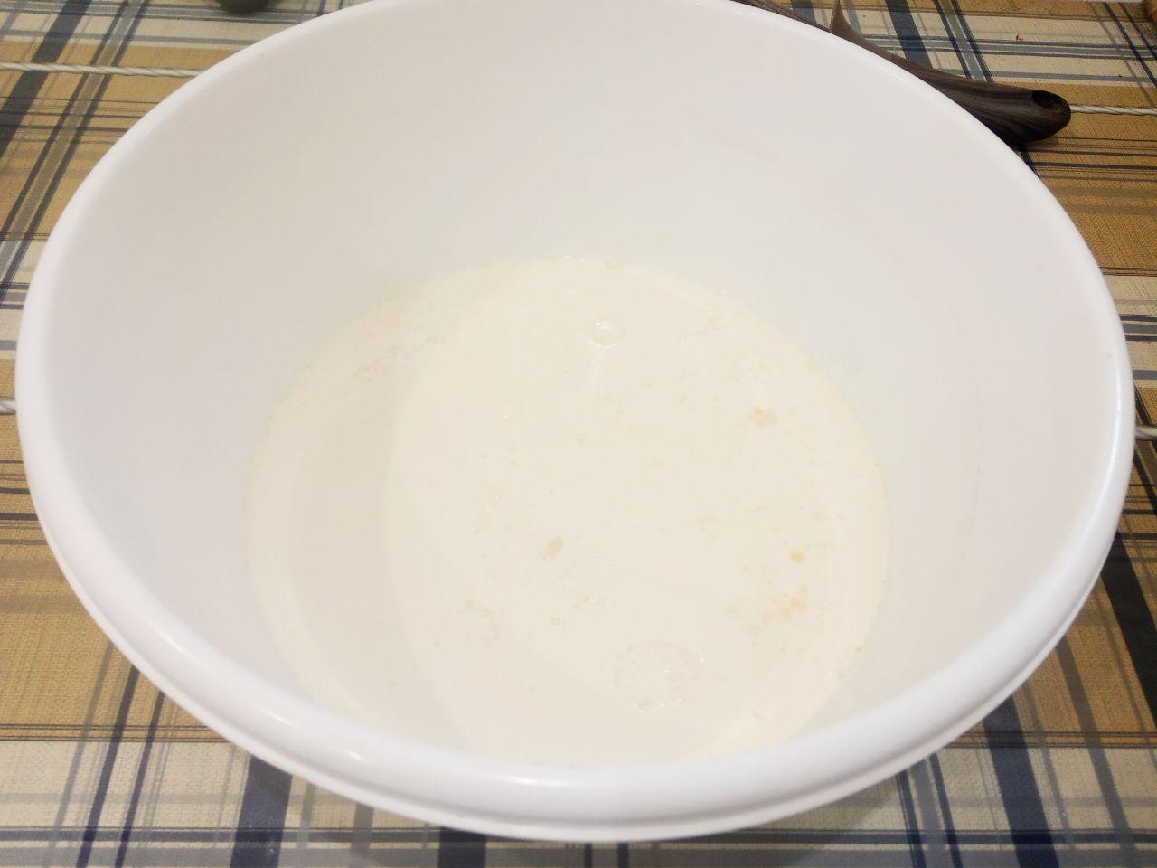 Жареные пончики без яиц с начинкой и с кунжутом: Всыпаем сахар, вливаем кефир и размешиваем.