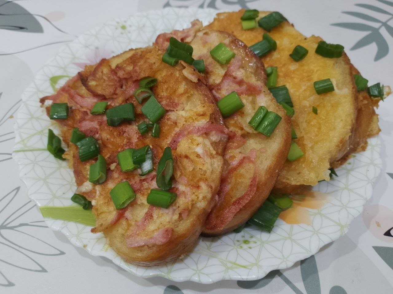 Бутерброды с яйцами и сыром, жареные на сковороде: Готовые ломтики выкладываем на тарелку и посыпаем зеленым луком.
