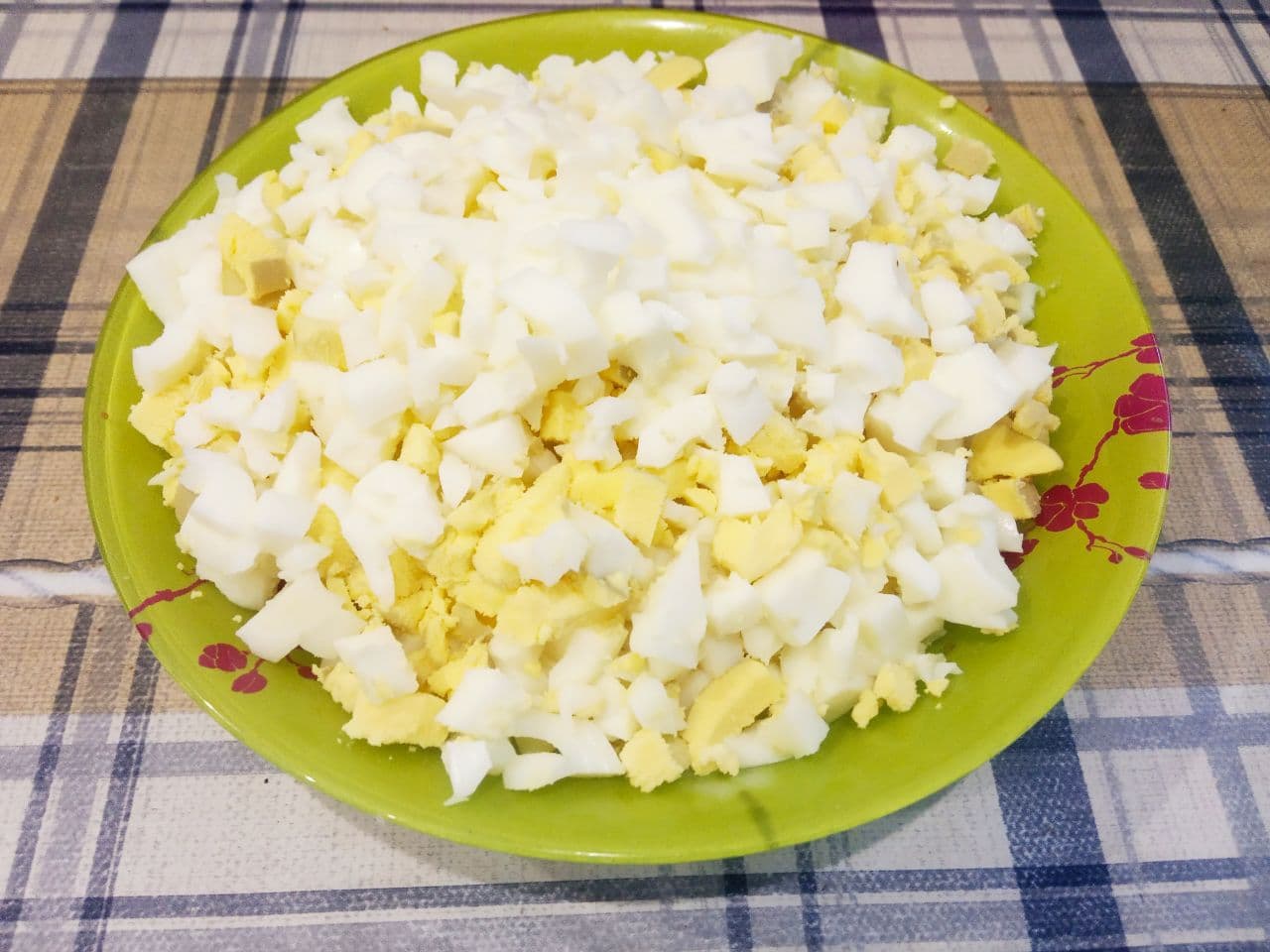 Простой рецепт салата с крабовыми палочками и кукурузой: Разрезаем яйца на мелкие кубики и выкладываем в емкость.