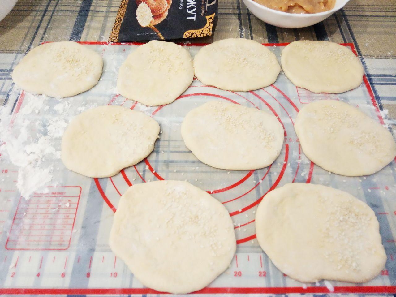 Жареные пончики без яиц с начинкой и с кунжутом: Лепешку смазываем молоком там, где будем посыпать кунжутом.