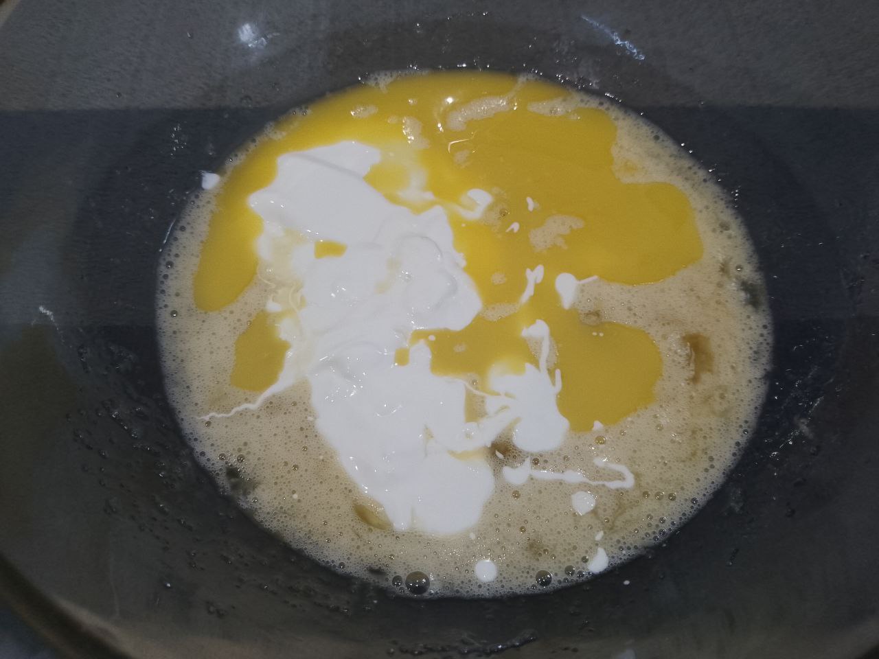 Мягкие вафли с вишней и начинкой, просто и вкусно: Добавляем сметану и растопленное сливочное масло в яичную смесь, размешиваем.