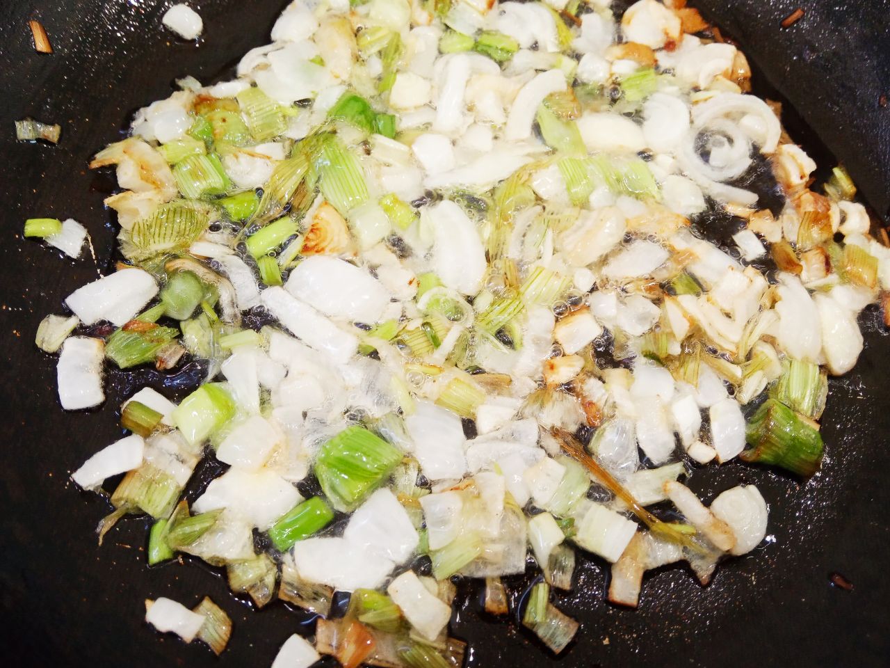 Острые чесночные стрелки жареные с луком и морковью: Разогревам сковородку с растительным маслом, кладем лук и обжариваем до золотистого цвета.