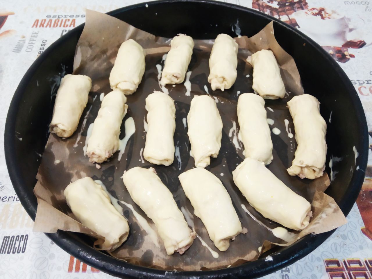 Пирожки из слоёного теста с мясной начинкой: Желток смешиваем со сметаной и смазываем пирожки.