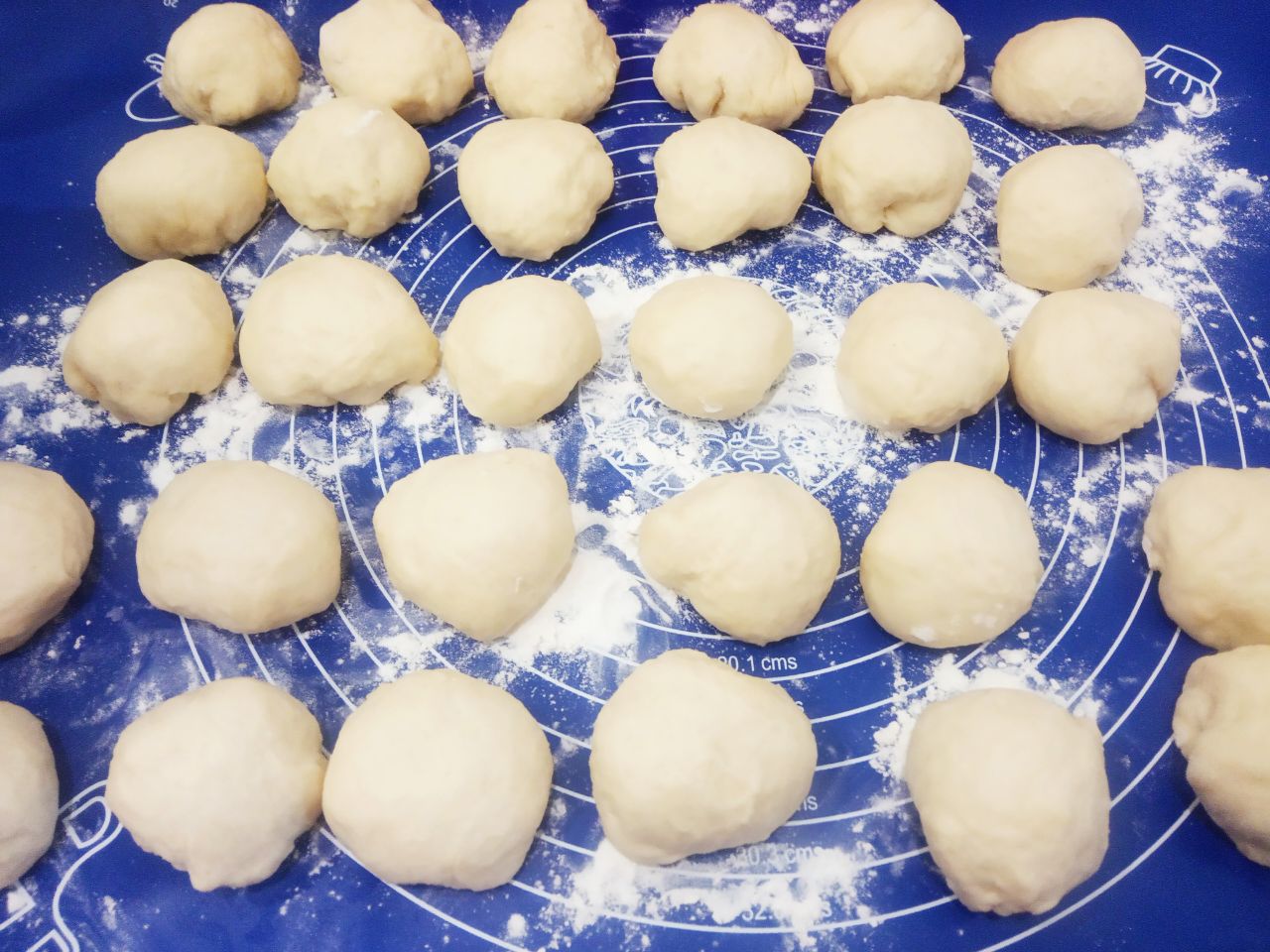 Пирожки из сдобного дрожжевого теста с вишней и клубникой, сочные и аппетитные: Тесто выкладываем на рабочую поверхность и разделяем на части небольшого размера. У меня вышло 48 колобков.