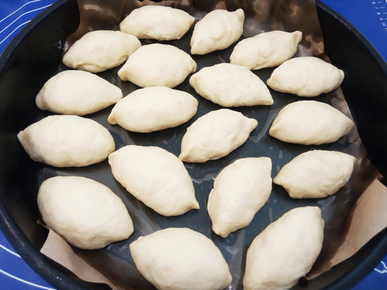 Воздушные и мягкие булочки с изюмом, в сахарной глазури: Противень застилаем пергаментом и укладываем булочки. Булочки оставляем для расстойки теста на 20 минут.