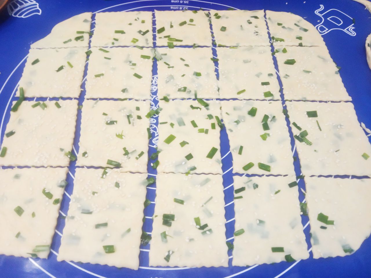 Солёное печенье с кунжутом и зеленым луком: Нарезаем тесто небольшими прямоугольниками.