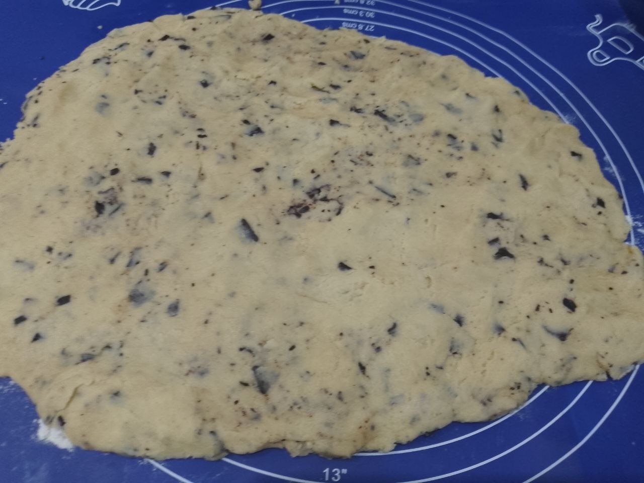 Домашнее печенье к чаю, с кусочками шоколада песочное и хрустящее: Рабочую поверхность посыпаем мукой и выкладываем тесто. Раскатываем тесто листом толщиной до 5 мм.