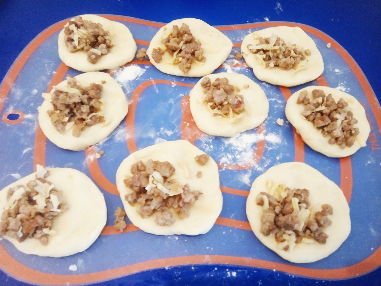 Пирожки с мясной начинкой и кунжутом, просто и вкусно: Шарики раскатываем и кладем начинку. Края соединяем и придавливаем вилкой.