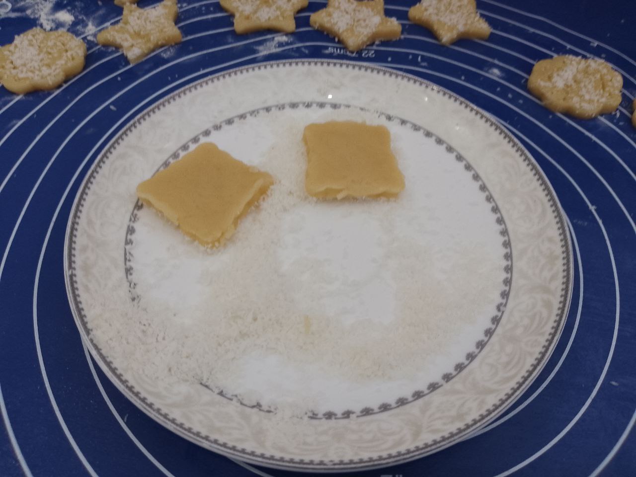 Домашнее печенье с кокосовой стружкой, песочное и рассыпчатое: В тарелку насыпаем кокосовую стружку и окунаем печенье.
