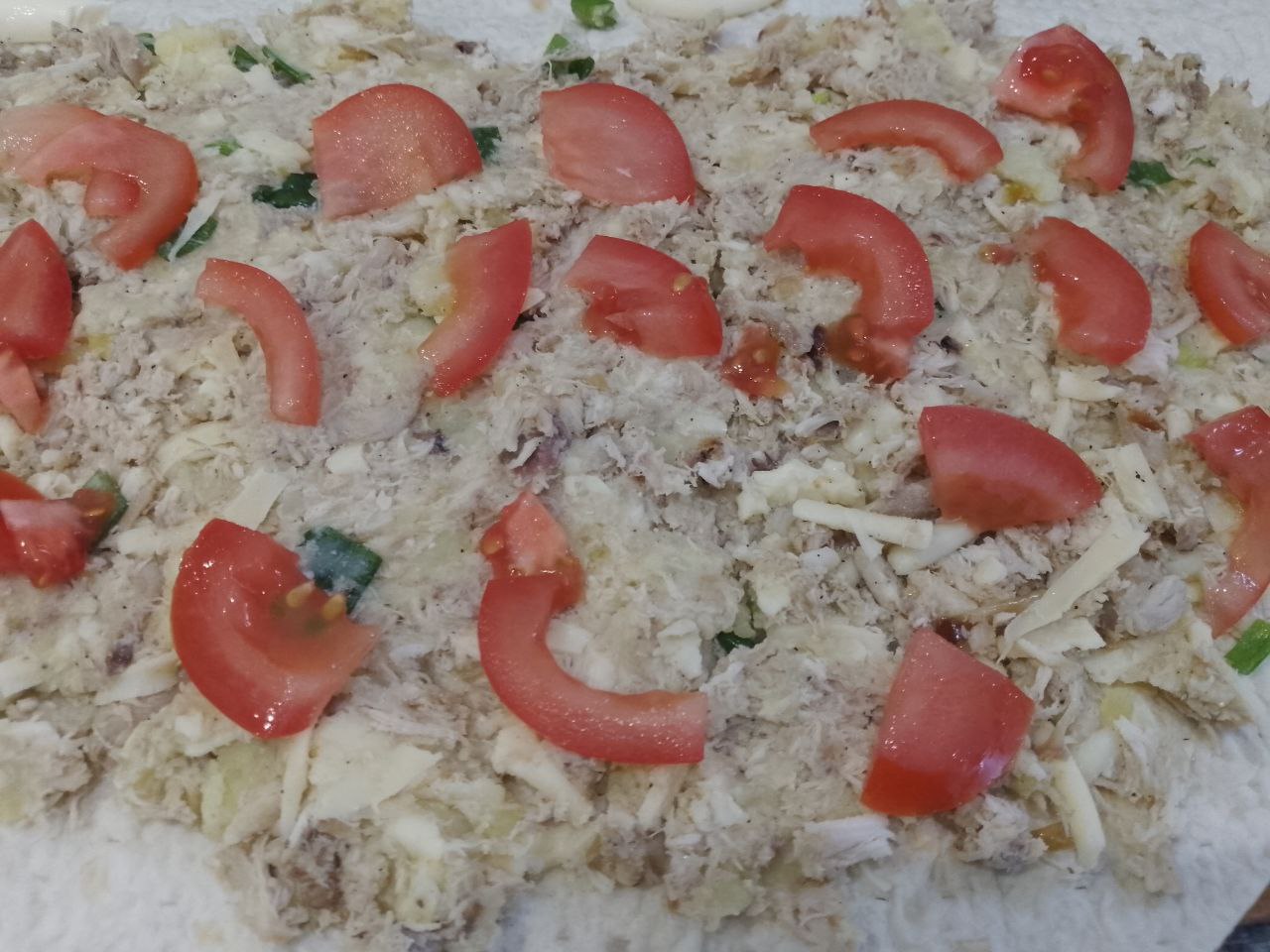 Лаваш с мясной начинкой в кляре, на сковороде: Распределяем ломтики помидоров по начинке и сворачиваем рулетом.