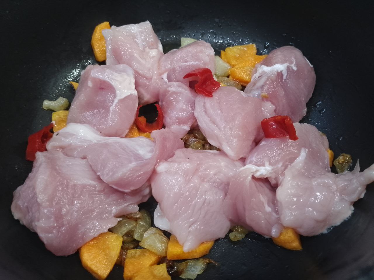 Пшенный острый суп со свининой и зеленью: Кладем кусочки мяса и измельченный красный перец, обжариваем.