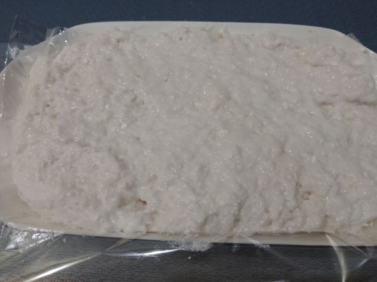 Вкусный апельсиновый десерт из желе и творога: Форму застилаем пищевой пленкой и выкладываем десерт, накрываем пленкой.