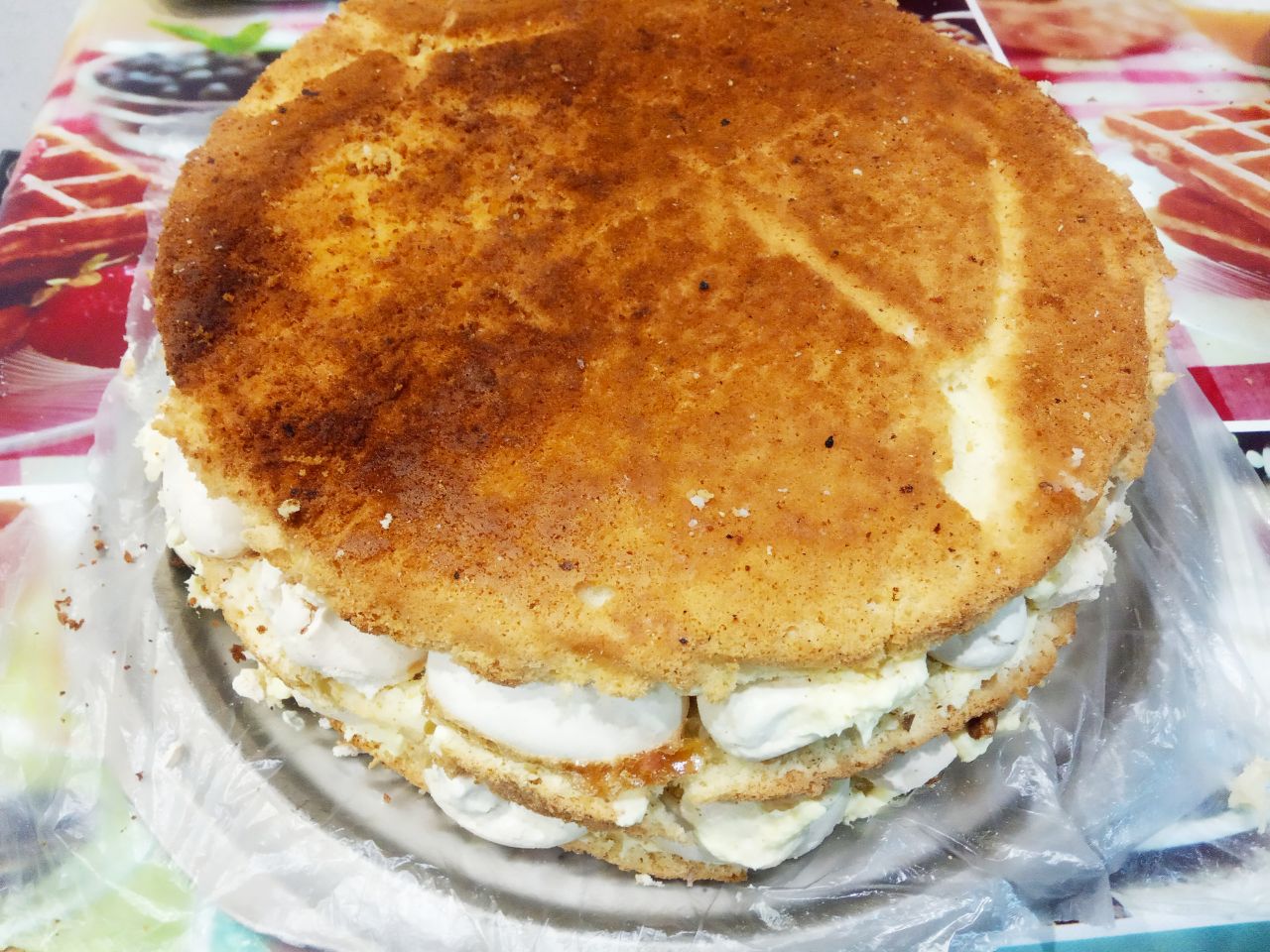 Вкусный торт ко дню рождения или к другому торжеству: Кладем на крем с орехами верхнюю часть бисквита и пропитываем сиропом.