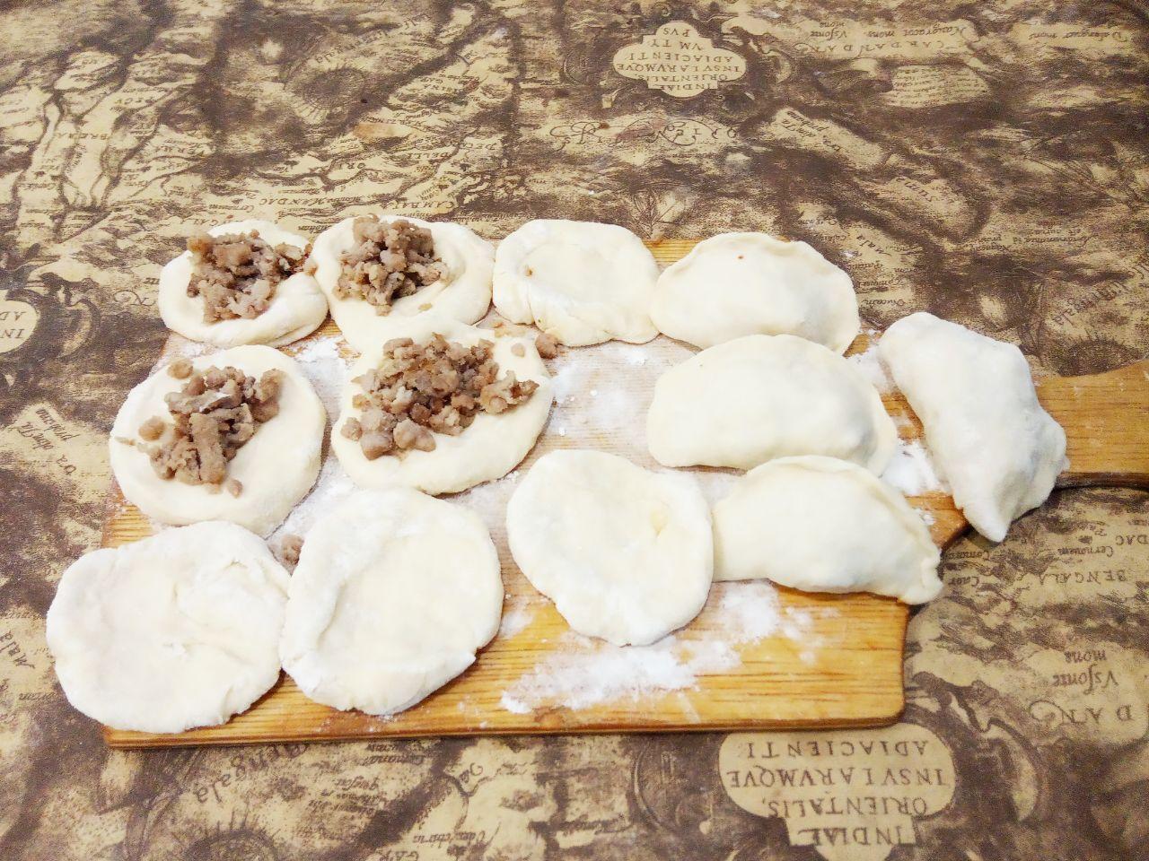 Вареники с мясом на пару: Накладываем фарш, соединяем края и защипываем.