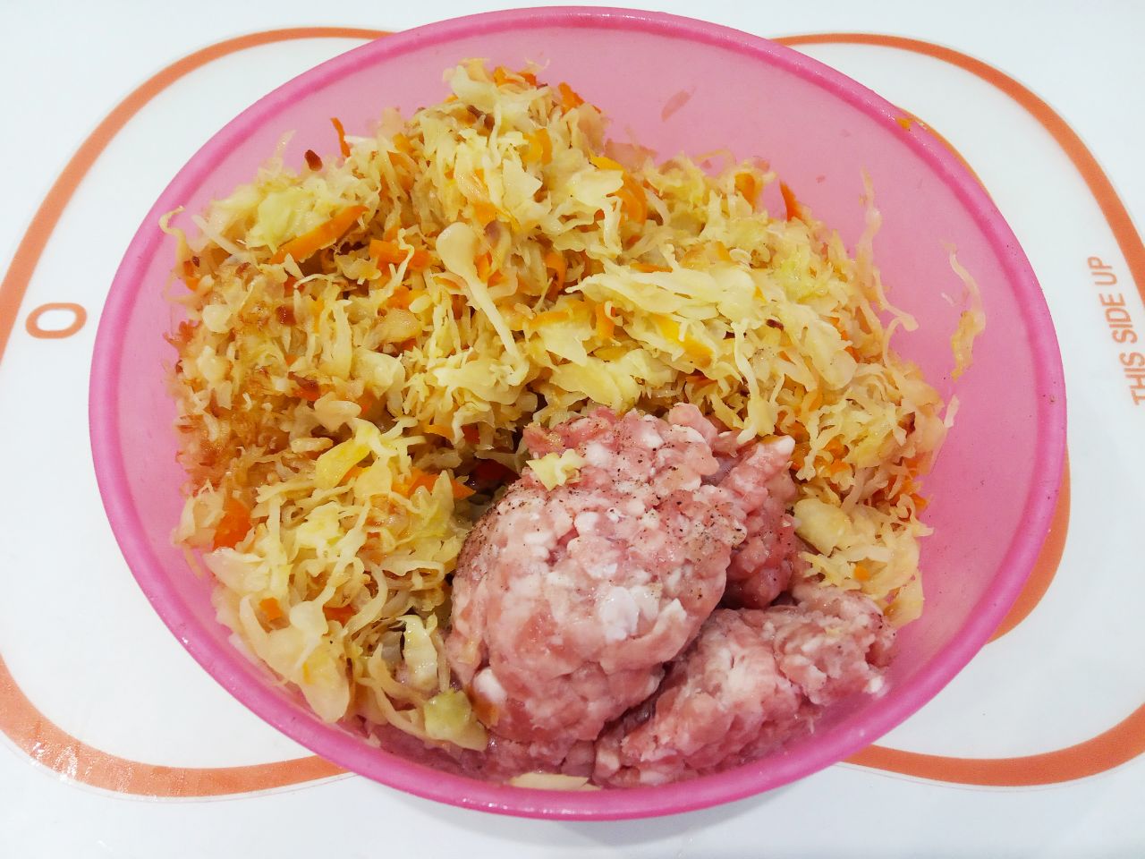 Капустные биточки с фаршем и соусом в духовке: Соединяем фарш, яйца и жареную капусту, добавляем соль и специи по желанию, тщательно размешиваем.