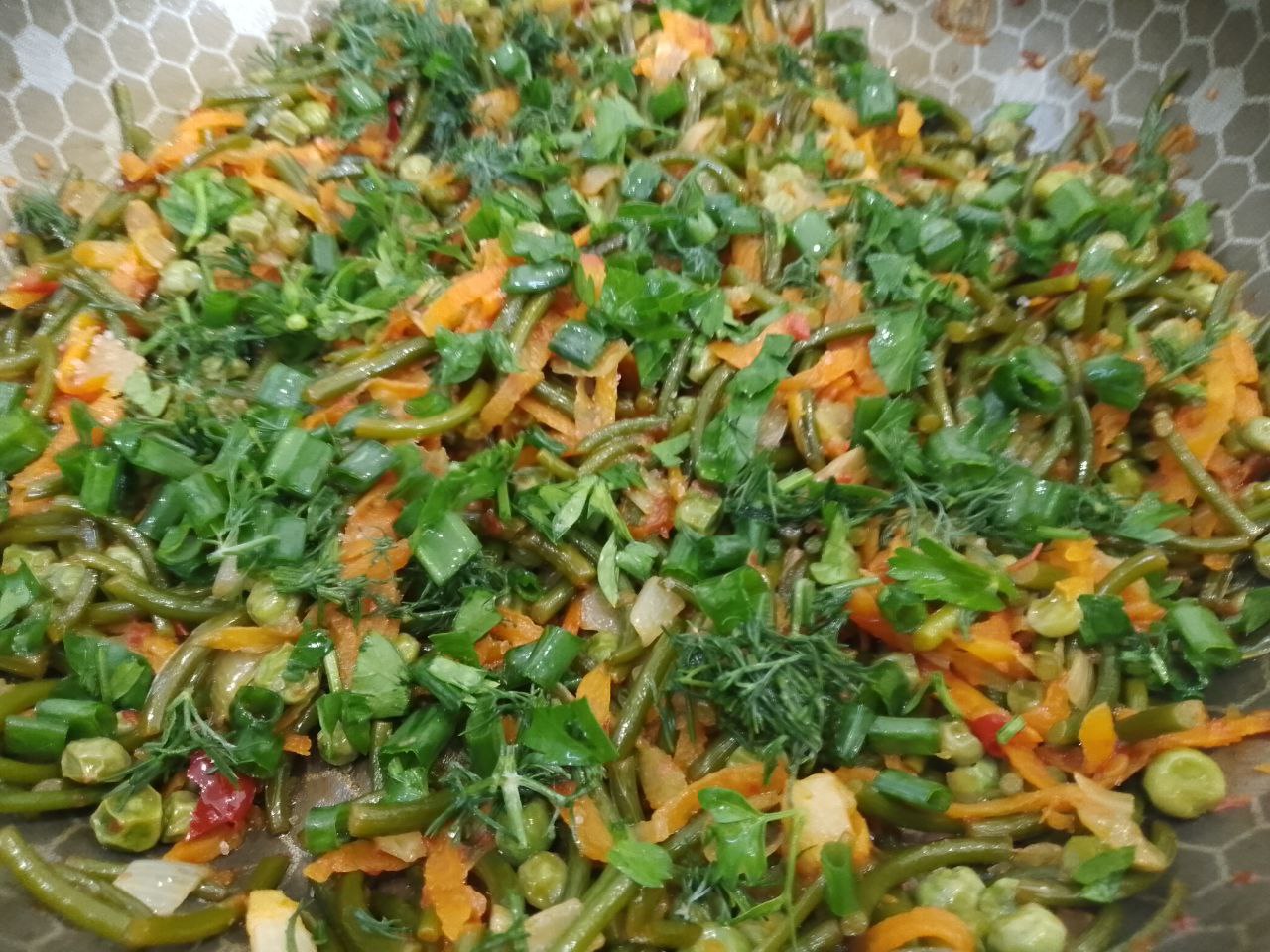 Острые чесночные стрелки с зеленым горошком и овощами, на сковороде
