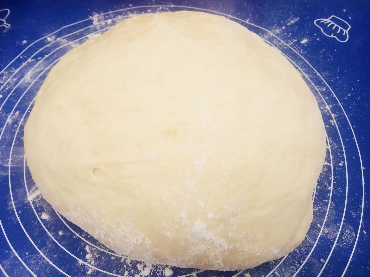 Воздушные и мягкие булочки, на сметане, с изюмом и корицей: Рабочую поверхность посыпаем мукой, выкладываем тесто.