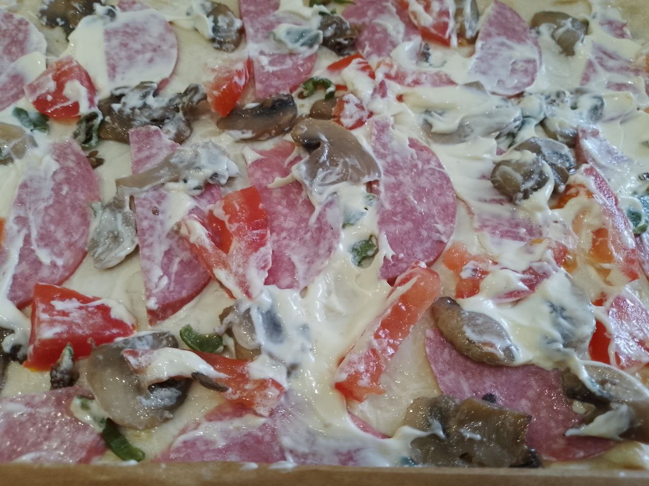 Домашняя пицца с шампиньонами, колбасой, помидорами и сыром: Сверху смазываем майонезом, посыпаем луком и тертым сыром.