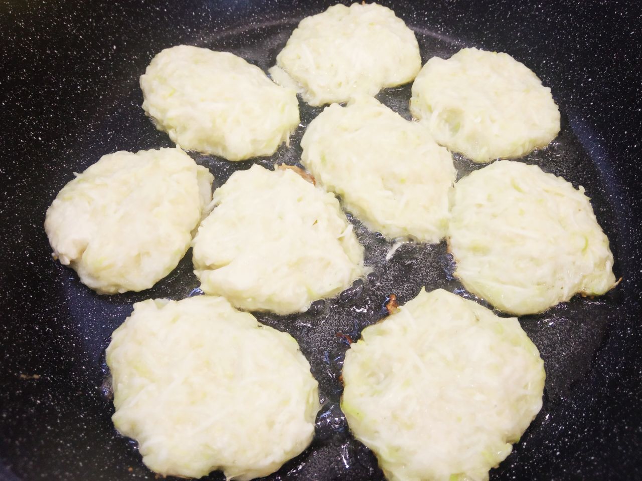 Простой рецепт овощных оладий из патиссонов, просто и вкусно: Разогреваем сковороду с растительным маслом и ложкой выкладываем массу для оладий, ложкой разравниваем.