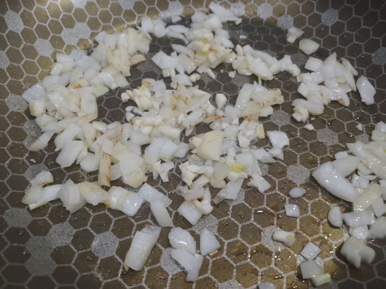 Запеканка зити с мясными шариками, сыром и протертыми помидорами: Разогреваем сковороду с растительным маслом, кладем измельченные лук и чеснок, обжариваем до золотистого