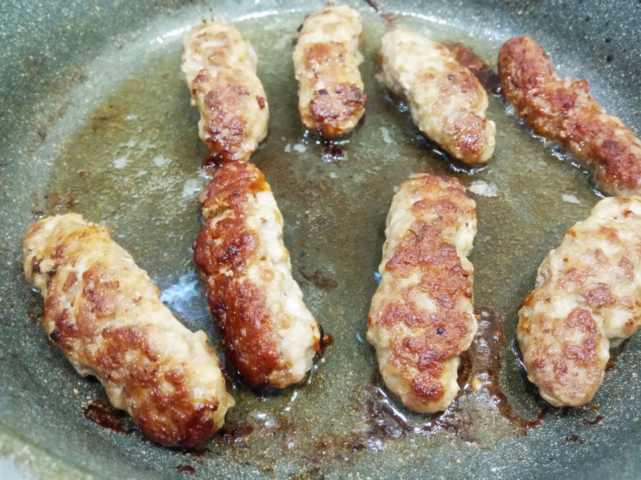 Мясные колбаски, жареные на сковороде, вкусные и аппетитные: Обжариваем колбаски с двух сторон на медленном огне под закрытой крышкой.