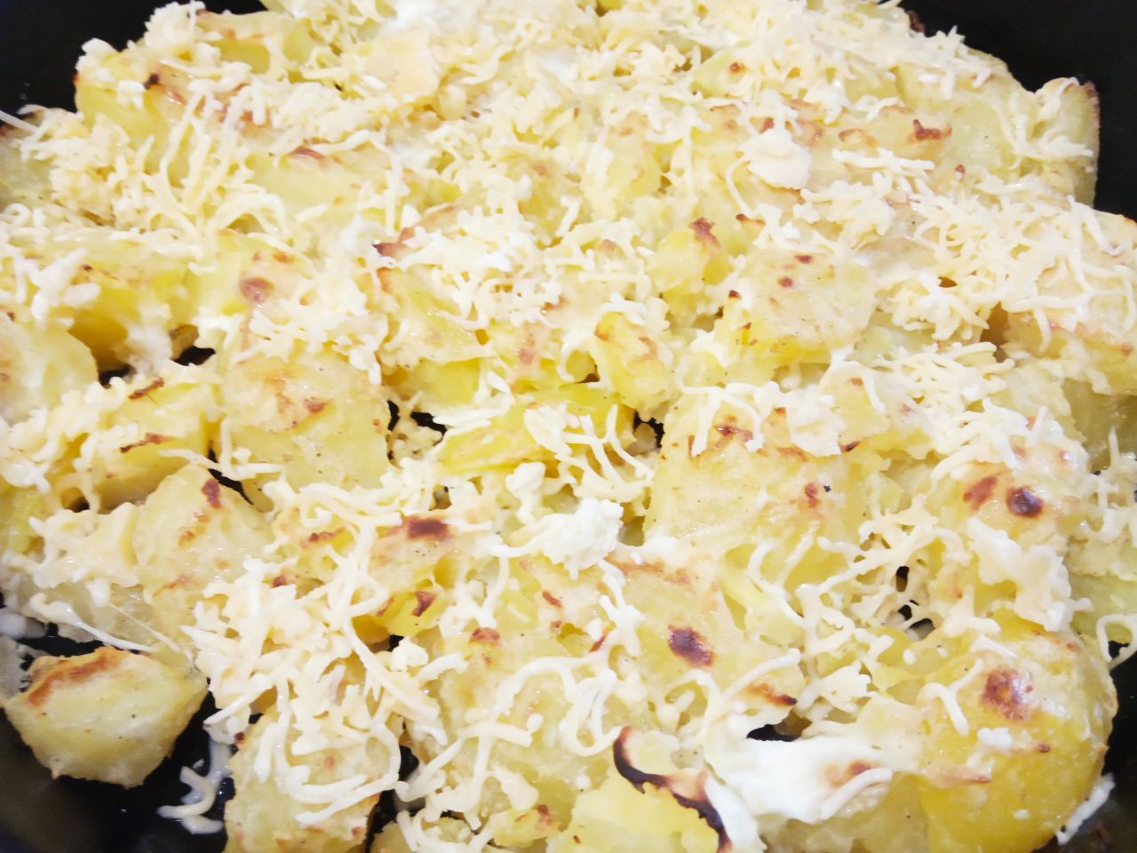 Запеченный молодой картофель в сметане и сыре: Достаем картофель из духовки и посыпаем тертым сыром, возвращаем ещё на 5 минут в духовку.