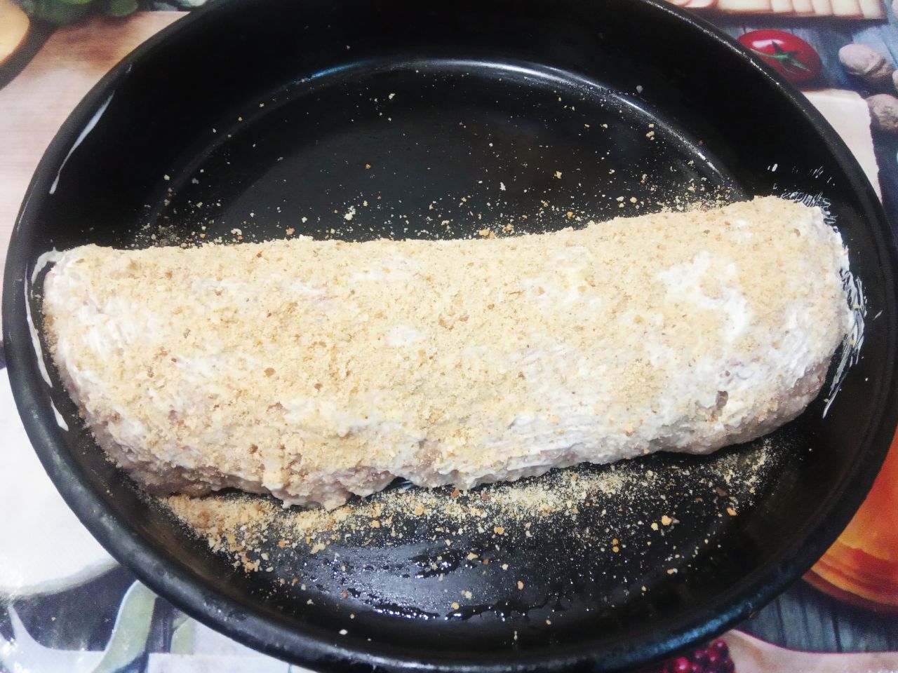 Мясной рулет с начинкой из грибов и жареного лука: Рулет перекладываем на противень, смазываем сметаной и посыпаем панировочными сухарями.