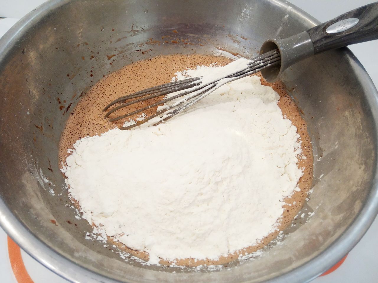 Шоколадные булочки из заварным кремом, нежные и воздушные: Муку смешиваем с солью, просеиваем через мелкое сито и половину добавляем в тесто, размешиваем.