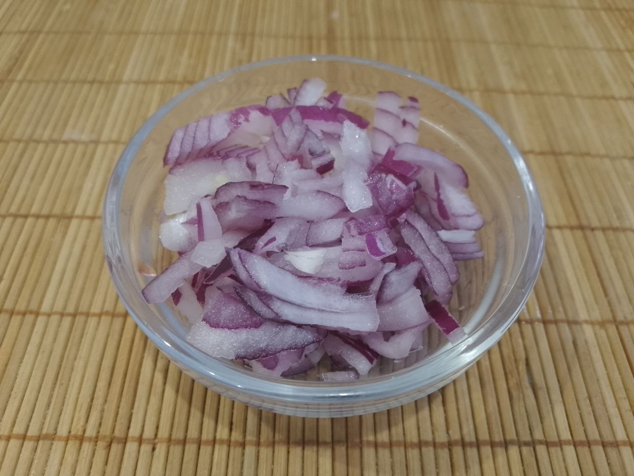 Сытный, вкусный и аппетитный салат из яичных блинов, ветчины и других ингредиентов: Репчатый лук очищаем, измельчаем и мелко нарезаем.