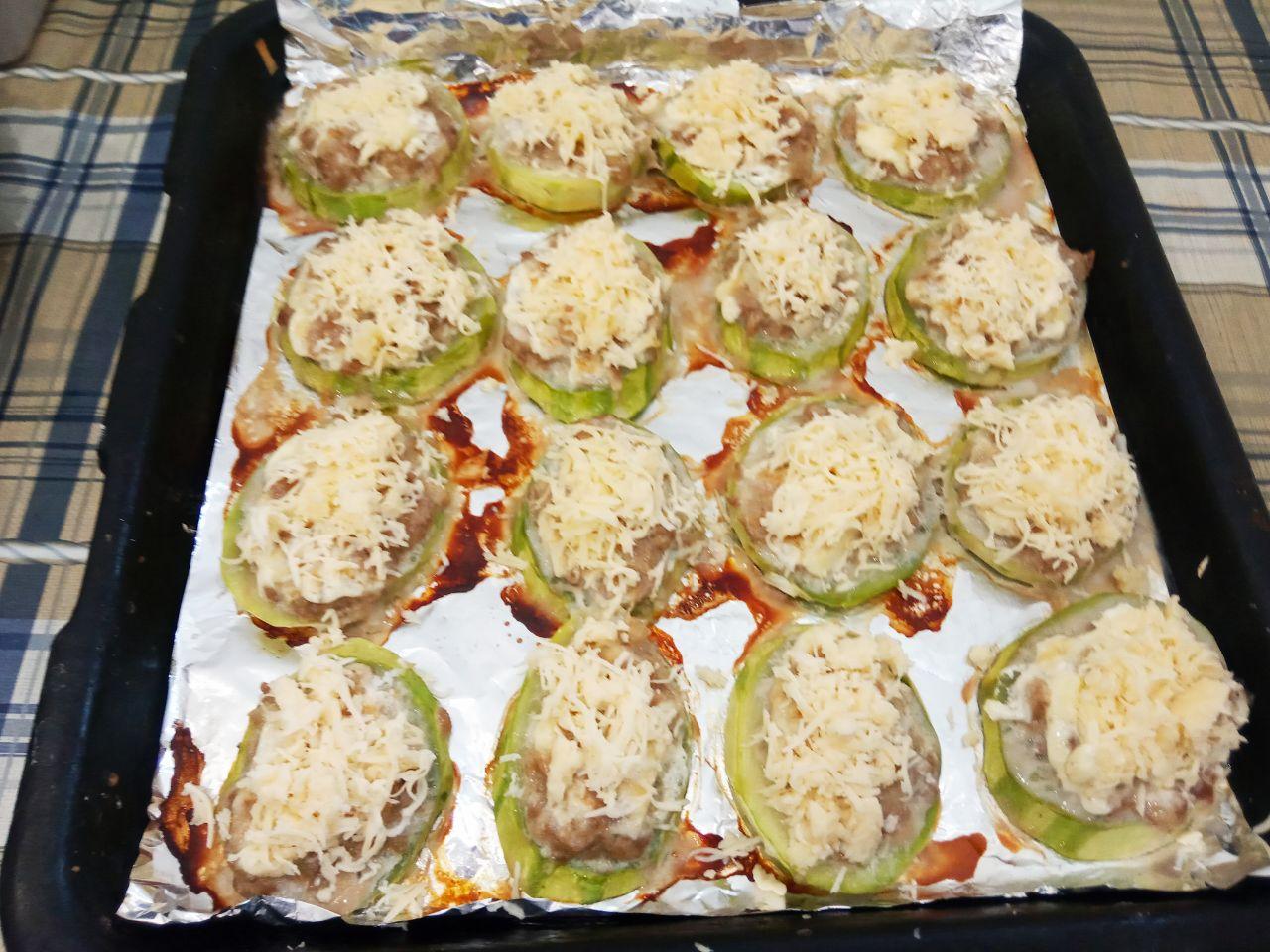 Вкусная закуска из кабачков с фаршем и сыром: Перед окончанием выпекания посыпаем сыром, когда сыр растает на кабачковой закуске, достаем из духовки.