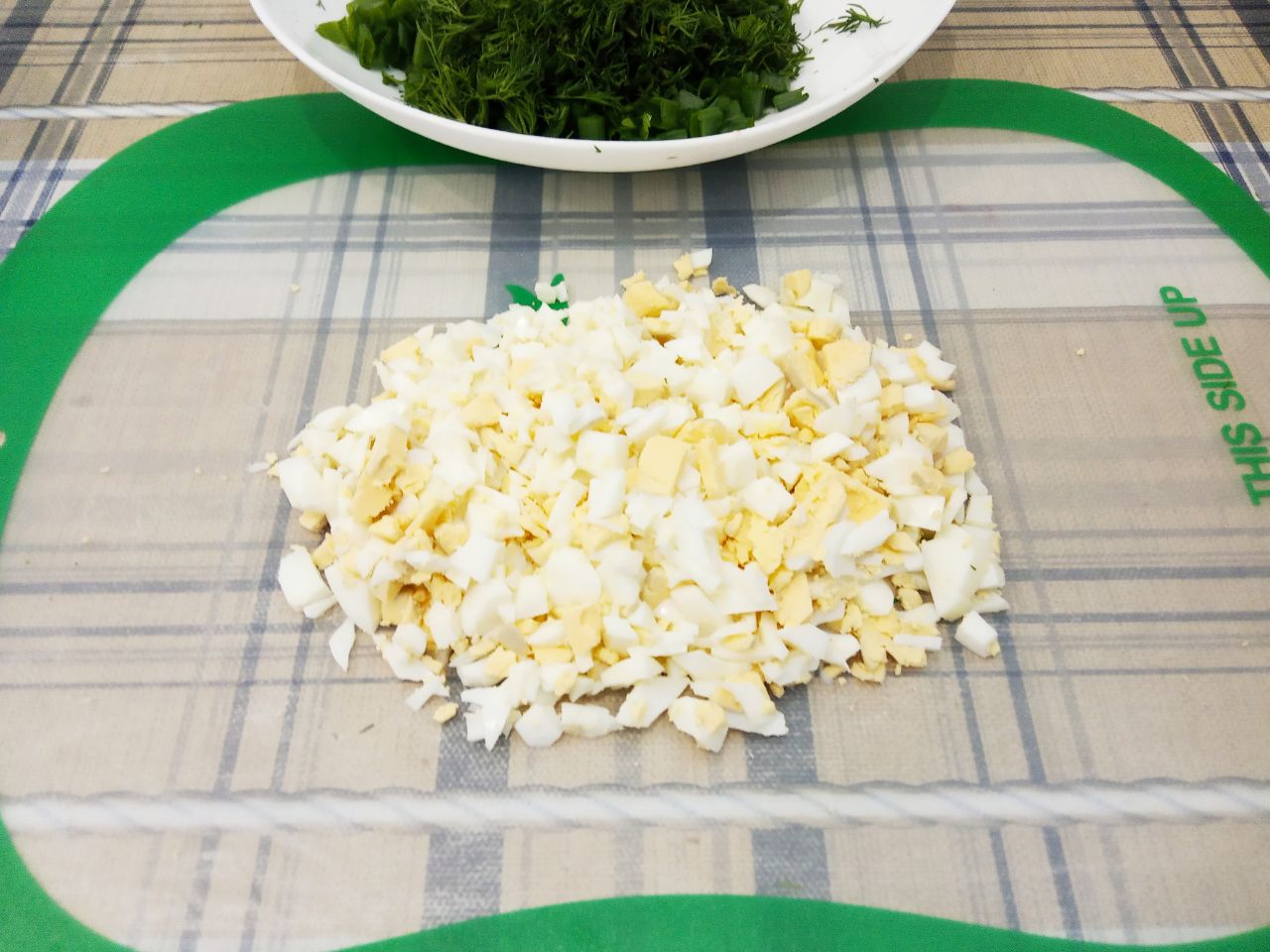 Простой салат с зелёным луком, яйцами и зеленью укропа: Яйца отвариваем вкрутую, очищаем от скорлупы и нарезаем кубиками.
