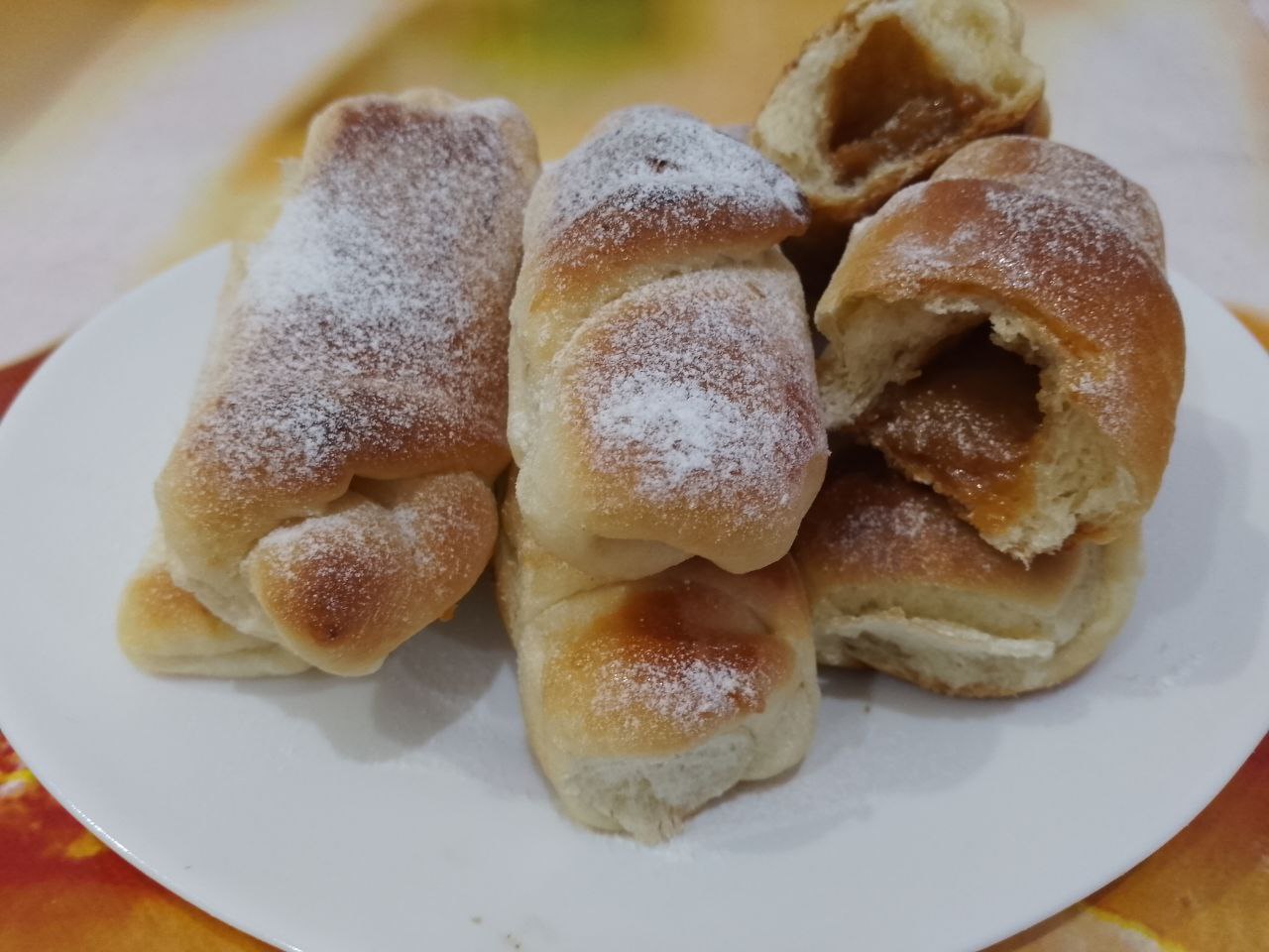 Рогалики из сдобного дрожжевого теста, с начинкой из вареного сгущенного молока: Рогалики посыпаем сахарной пудрой, охлаждаем и укладываем на блюдо или поднос.