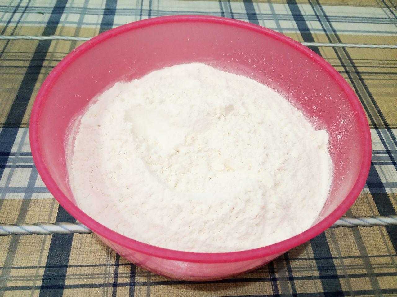 Жареные пончики без яиц с начинкой и с кунжутом: Муку просеиваем и добавляем в смесь, добавляем соль и замешиваем мягкое тесто.
