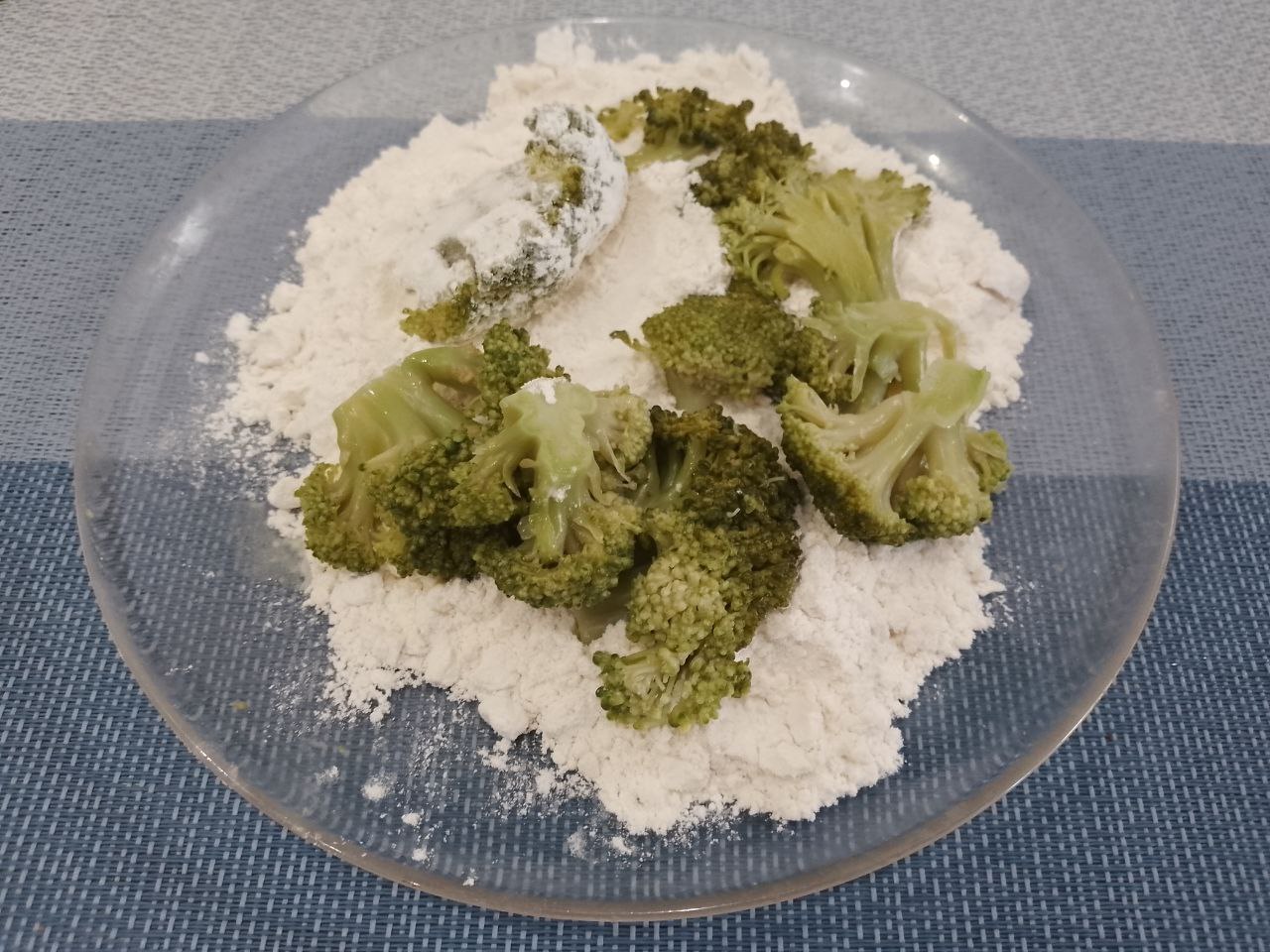 Капуста брокколи жареная в кляре из яиц, просто и вкусно: В тарелку насыпаем муку и обваливаем капусту в муке.