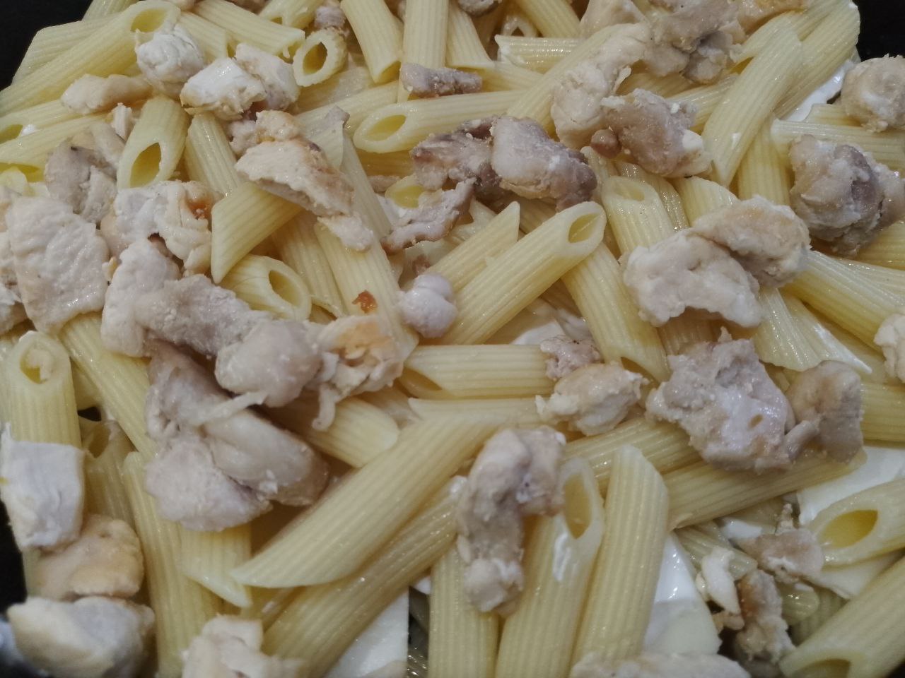 Макаронная запеканка с курицей, сыром и помидорами: Выкладываем вторую часть макарон, на макароны выкладываем половину обжаренного мяса.