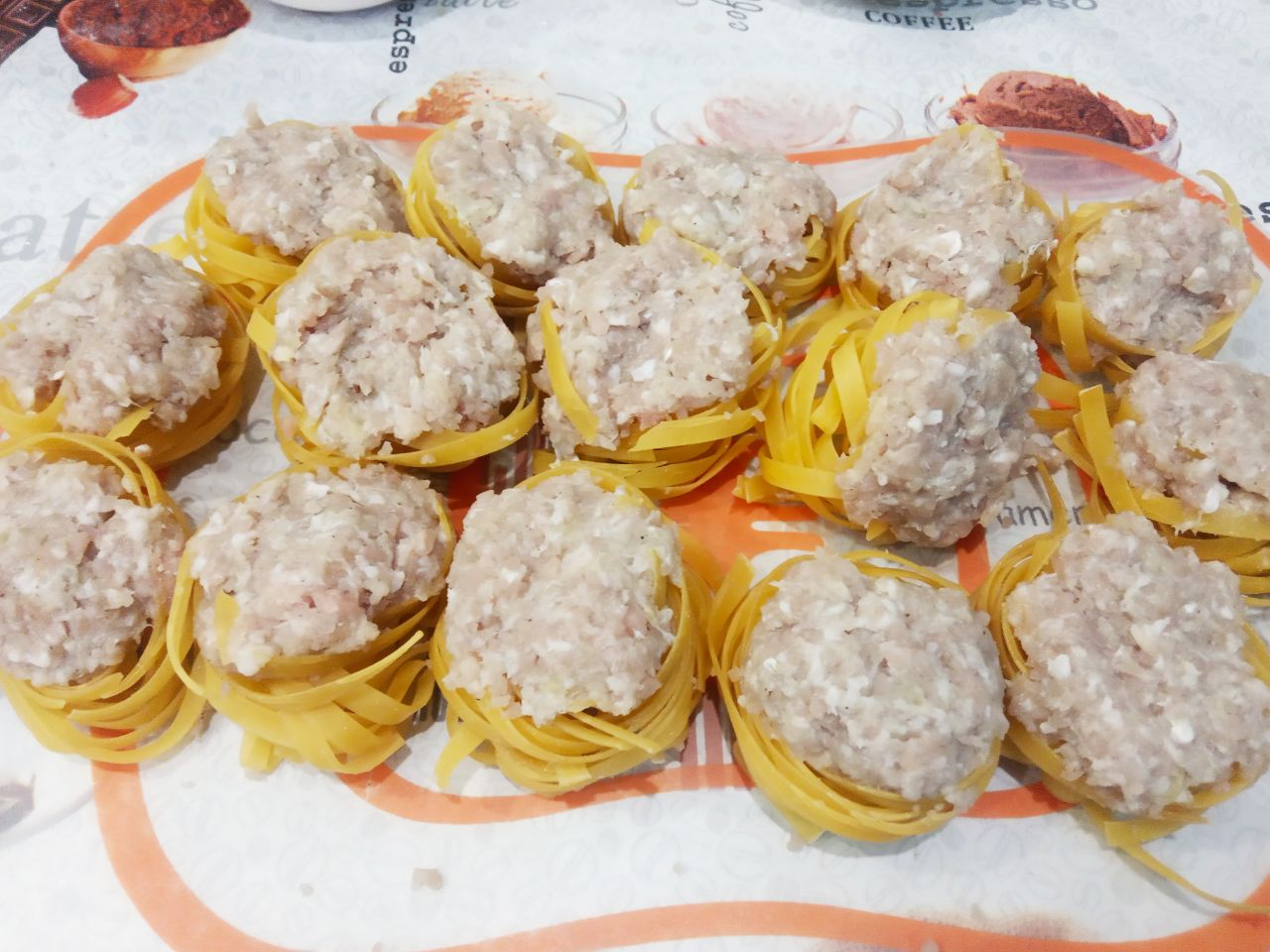 Макаронные гнёзда с фаршем и сыром на сковороде: Макаронные гнезда плотно наполняем начинкой и укладываем фаршированные гнёзда в сковороду. Доливаем водой