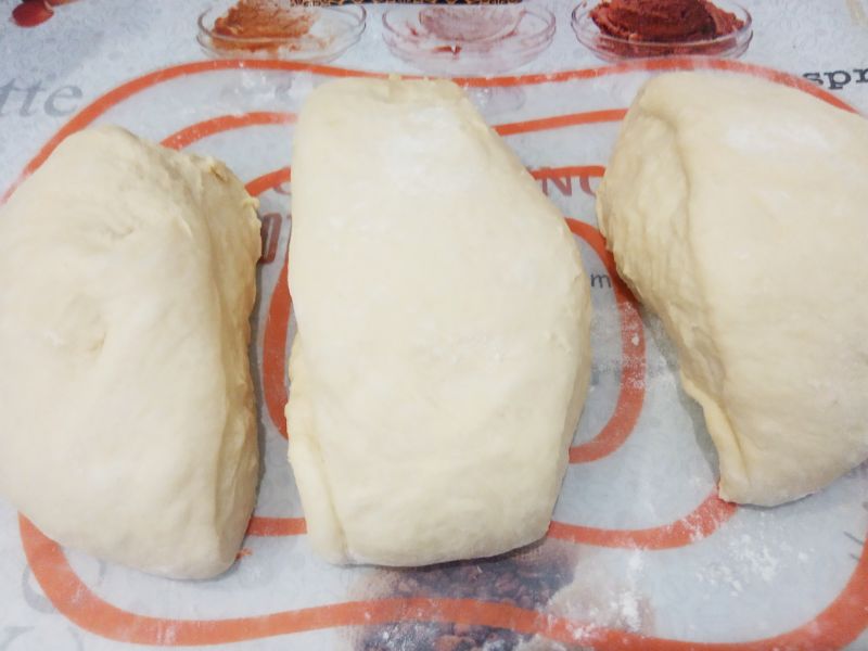 Домашние батоны с кунжутом на сыворотке, просто и вкусно: Выкладываем тесто на рабочую поверхность, перемешиваем и разделяем на три части.