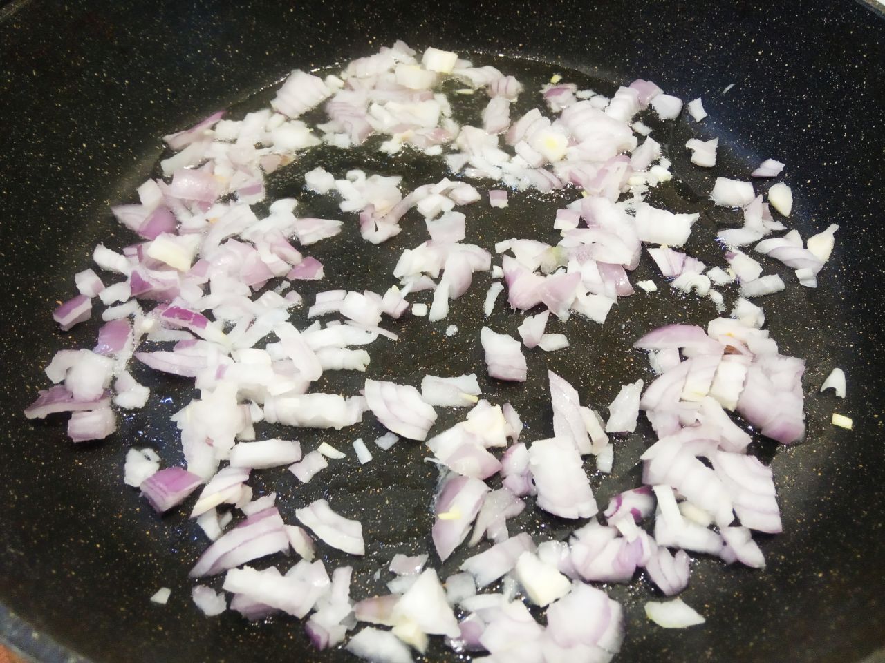 Пирожки из слоёного теста с мясной начинкой: Разогреваем сковороду с растительным маслом, кладем лук и обжариваем до золотистого цвета.
