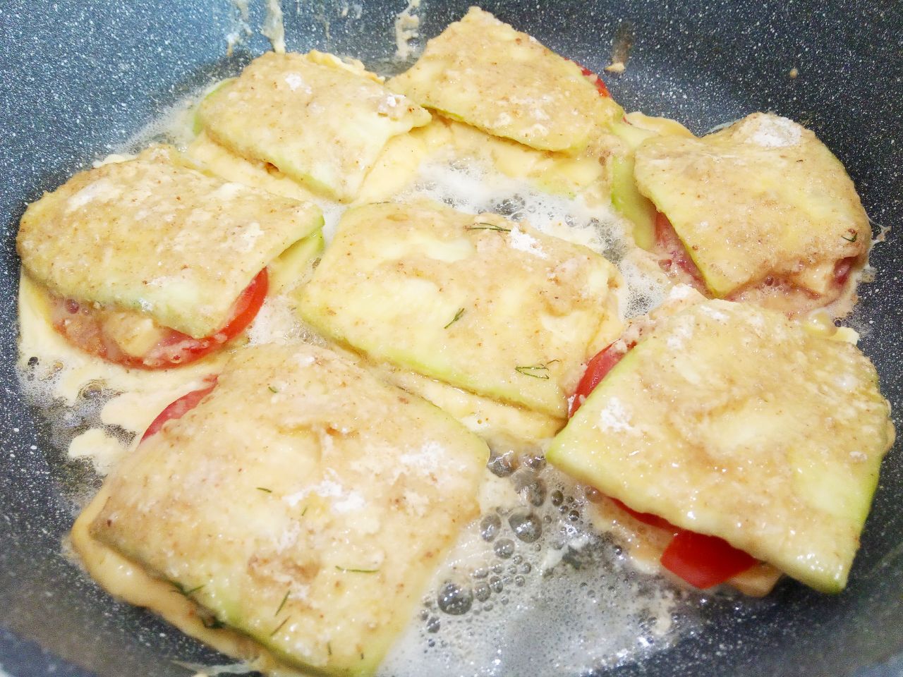 Кабачки с начинкой из помидоров и сыра, жареные в яичном кляре: Полоски с начинкой окунаем во взбитые яйца и укладываем на сковороду.