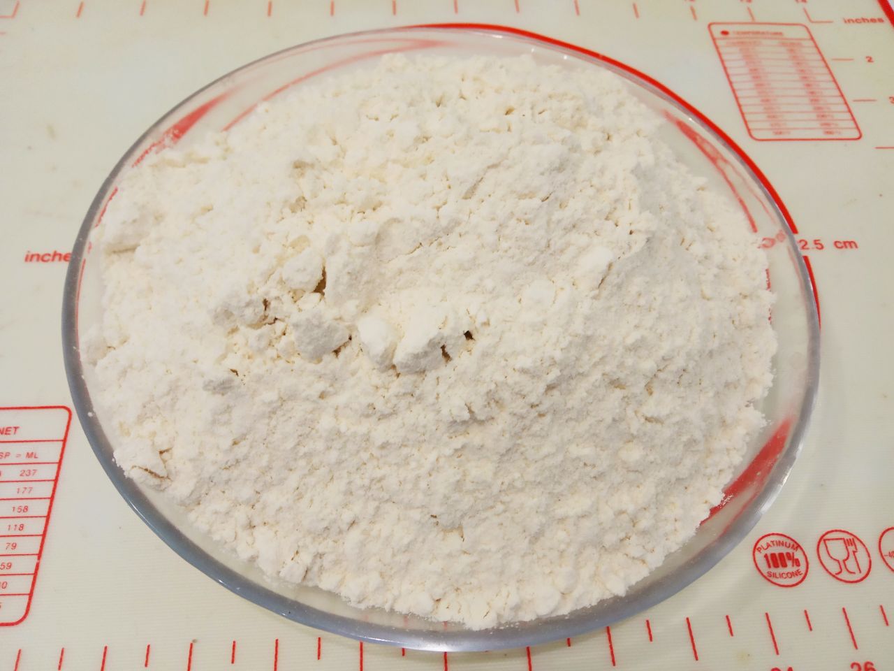 Булочки с изюмом в мучной крошке, воздушные и вкусные: Муку просеиваем через мелкое сито, смешиваем с солью и большую часть добавляем в смесь, размешиваем.