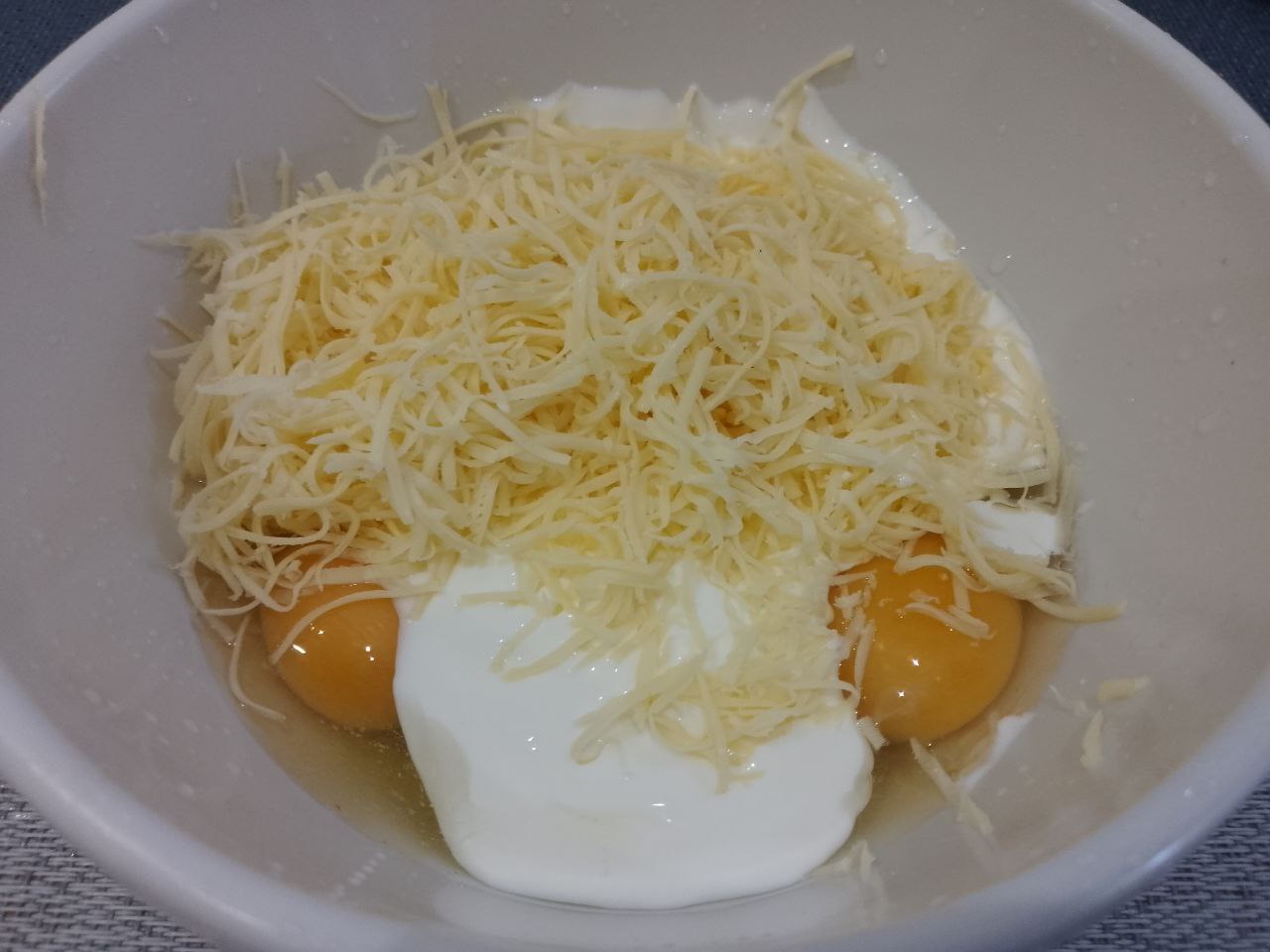 Картофельная запеканка с куриным филе, в духовке: Яйца разбиваем в миску, добавляем сметану и тертый сыр, размешиваем.