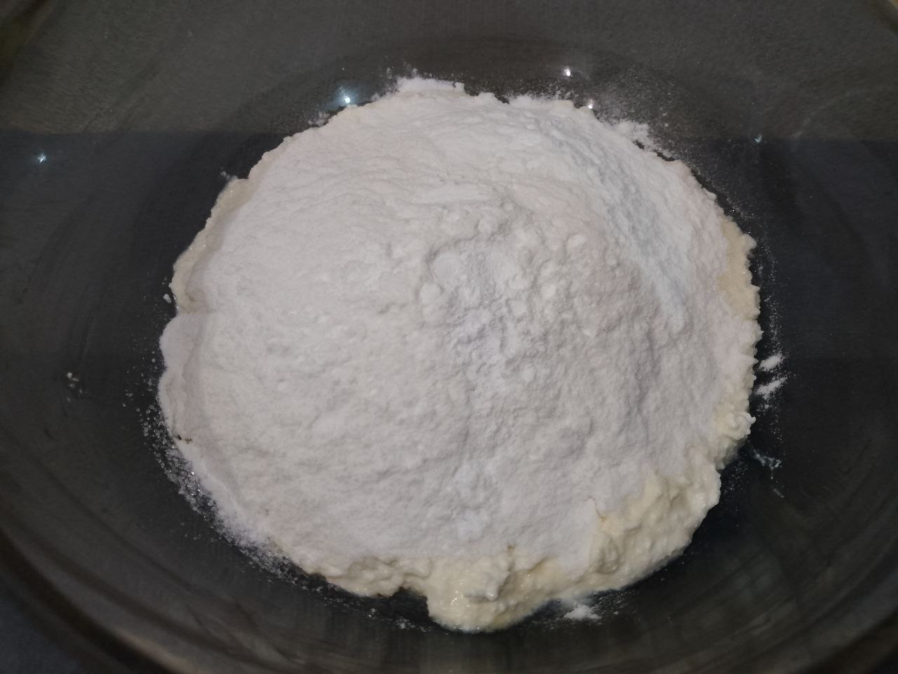 Сырники из творога, рисовой муки и кокосовой стружки: Добавляем муку с разрыхлителем для теста в творожную массу и тщательно размешиваем.