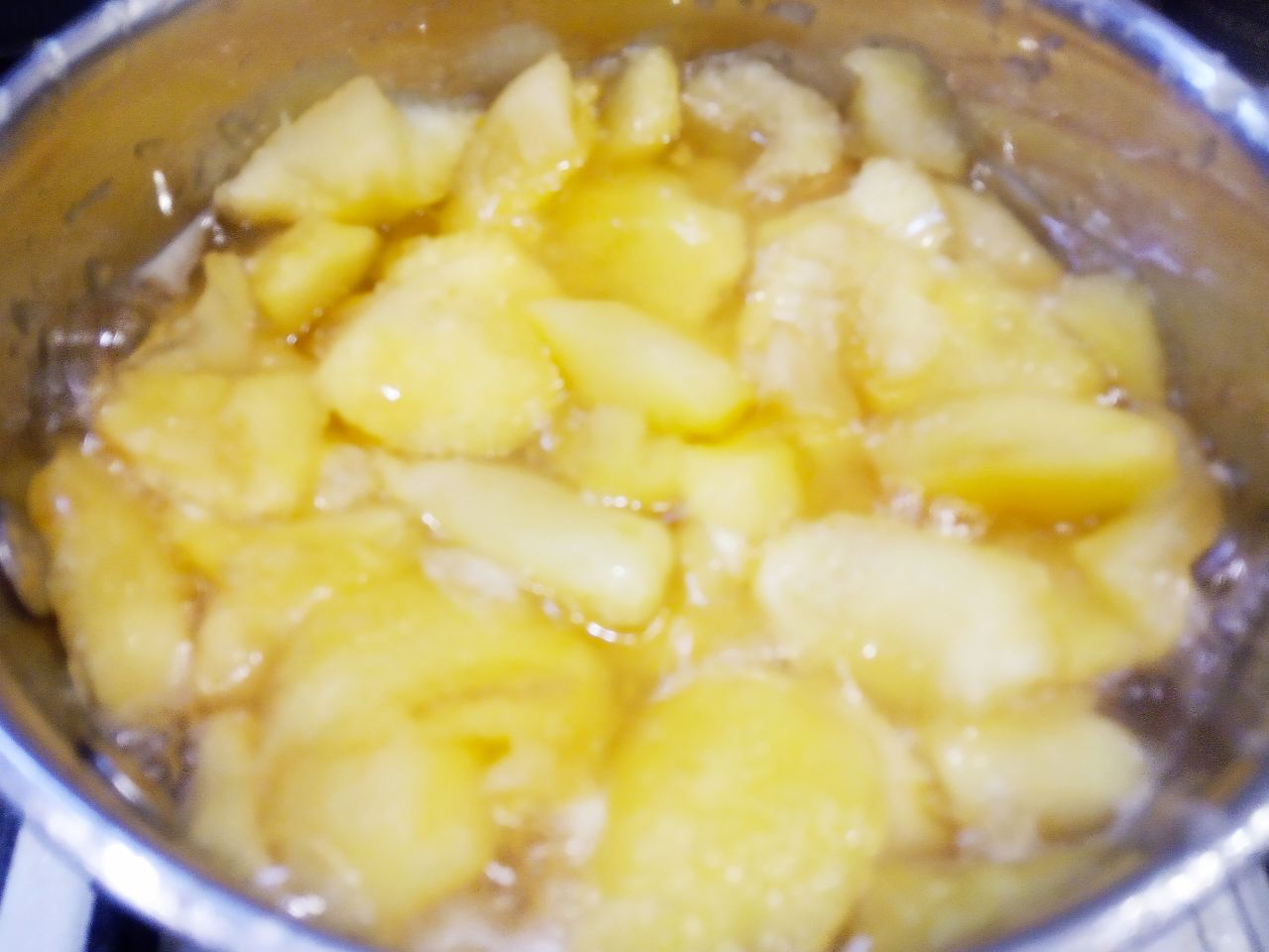 Вкусный десерт из яблочного желе и лимона: Ставим сотейник на огонь, доводим до кипения и варим дольки яблок в сиропе на слабом огне около 15-25 минут,