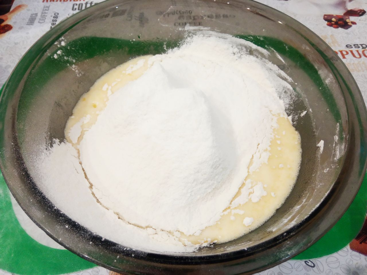 Мандариновое печенье на растительном масле, мягкое и рассыпчатое: Муку просеиваем через мелкое сито и большую часть добавляем в смесь, размешиваем лопаткой.