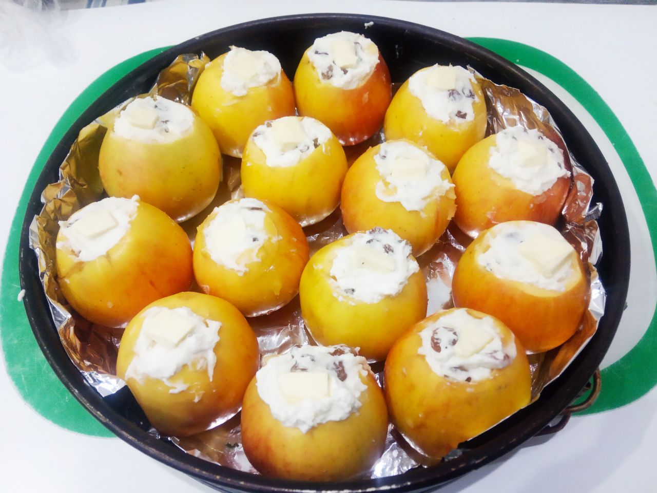 Нежные и сочные запеченные яблоки с творогом и изюмом: Сверху кладем кусочки масла.