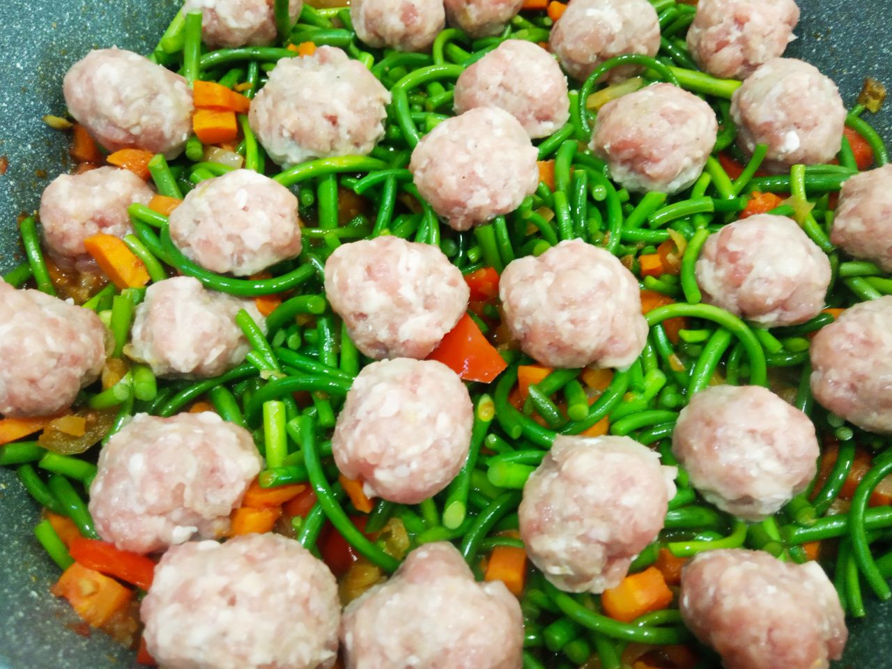 Чесночные стрелки с овощами, томатным соусом и мясным фаршем: Кладем к овощам чесночные стрелки, мясные шарики, соль и перец по вкусу, заливаем горячей кипяченой водой,