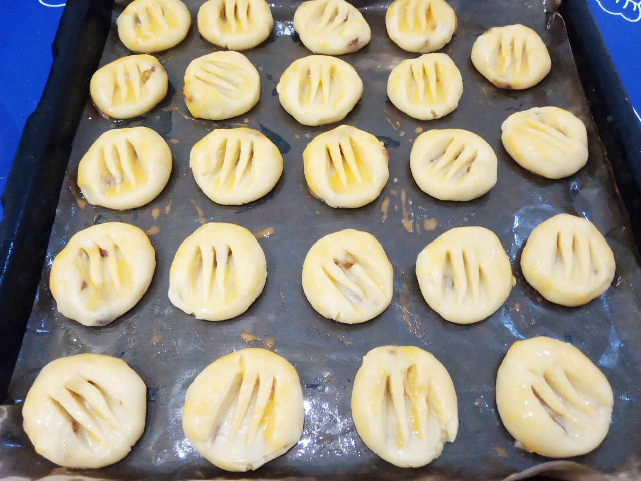 Домашнее печенье на растительном масле с изюмом, песочное и рассыпчатое: Желток размешиваем с молоком и смазываем кондитерской кисточкой печенье.
