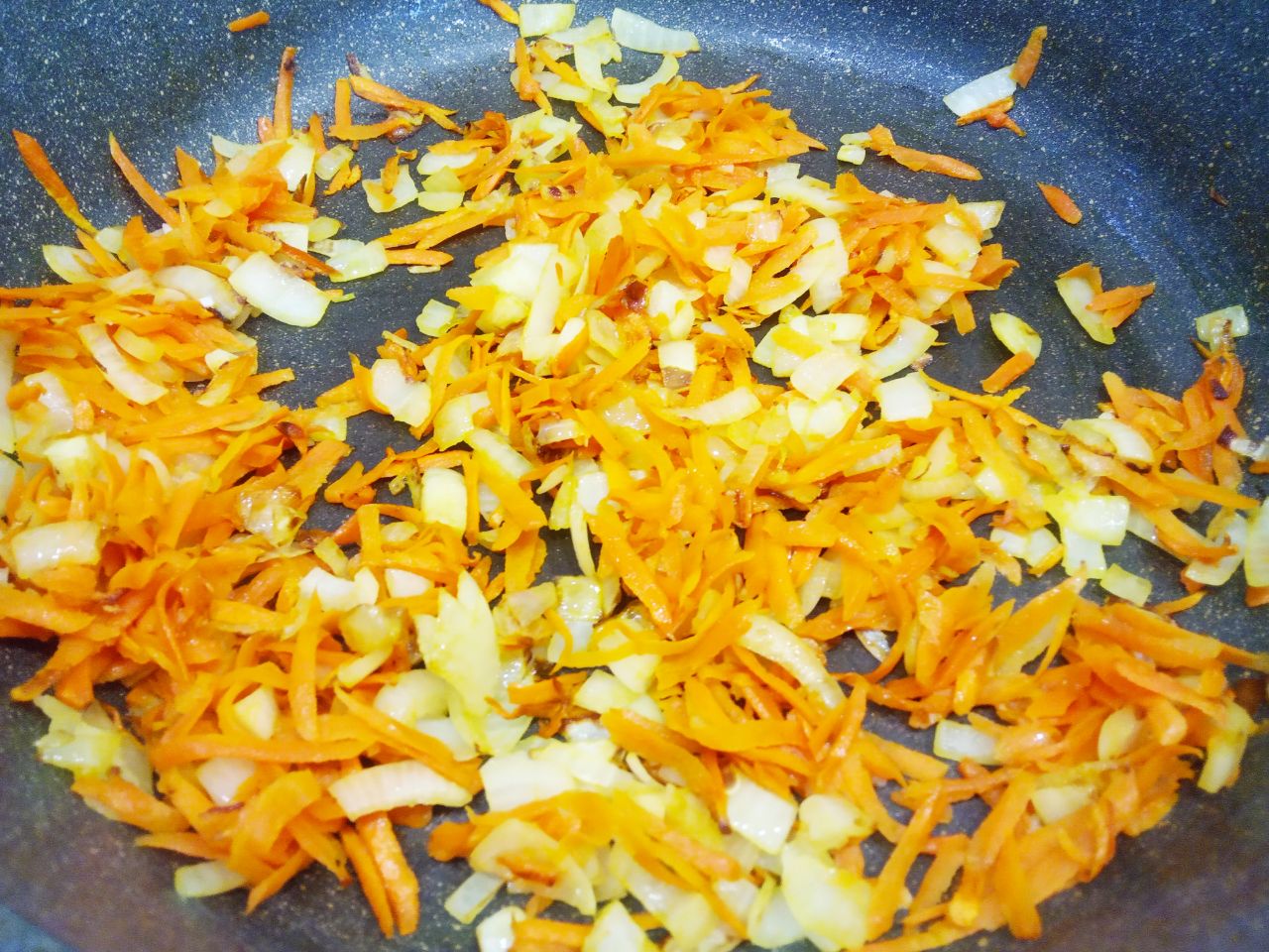 Красная чечевица тушеная с овощами и мясными шариками: Разогреваем сковороду с растительным маслом, выкладываем измельченный лук и морковь и обжариваем.