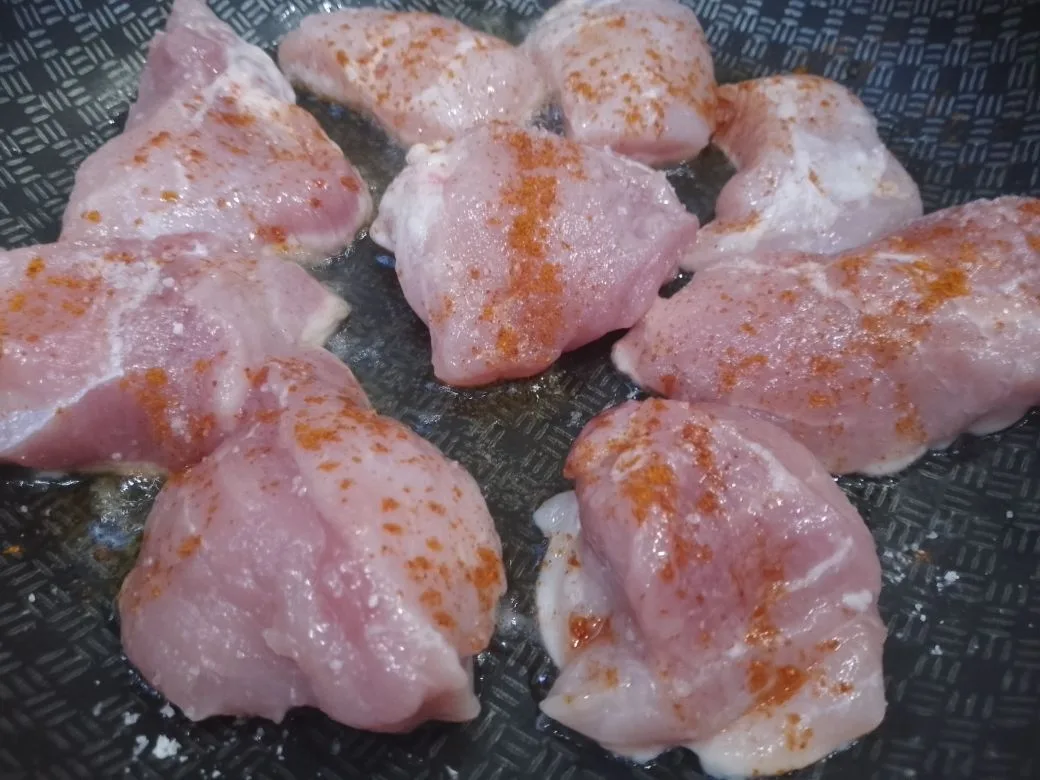Тушеное мясо свинины с овощами: На разогретую сковороду с растительным маслом выкладываем кусочки мяса, солим и перчим по вкусу, обжариваем