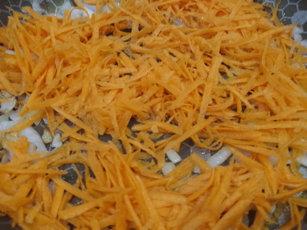 Грибы запеченные в духовке с морковью и луком, сочные и вкусные: Добавляем тертую морковь и обжариваем несколько минут.